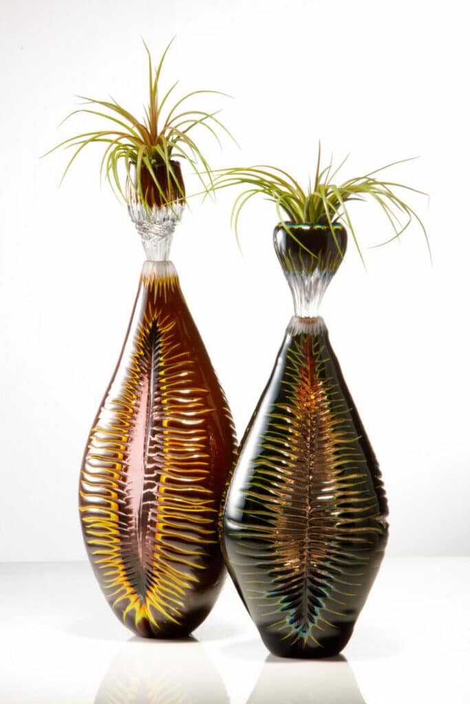 Nurturing Growth Bottles Made by Allister Malcolm Glass Limited Here is a preview of some of Allister’s latest designs. Developed in celebration of the studio’s achievements in becoming more sustainable. These pieces house an air plant nestled in the stopper. Handblown glass with multiple overlays, hand cut and fire polished.