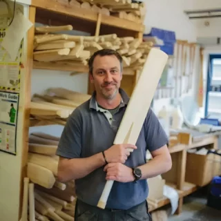 This week’s #craftfocus is cricket bat making. 

The making of willow cricket bats involves the following steps: 

- Grading, selecting and seasoning the timber
- Machining the clefts and pressing the bats to compress the fibres (pressing happens at several stages) 
- Fitting the handle into the blade and shaping the blade with a drawknife
- Shaping the shoulders and handle with a drawknife and rounded spoke shave
- Sanding the shaped bat, rasping the handle, binding the handle with linen thread, and polishing the completed bat 

Cricket bat making is classified as endangered on our crafts list. Threats to its viability include the issue of brand versus manufacturer. While there are nearly fifty bat ‘brands’ claiming to make in the UK, only 12-13 are genuine. Many brands sell bats that are made in South Asia and only finished in the UK. Other people might buy-in parts and only finish the bats themselves. It is very difficult for the consumer to know which is which. 

With the market largely covered by imported bats, demand is reduced and it is very difficult for bat makers in the UK to compete or make a living from bat making. 

Cricket bats can only be made from English cricket bat willow and an abundance of this is sent to India/Pakistan for production there. The price of English willow is increasing each year and the cost of machinery and infrastructure needed to store it is also high. The craft workforce is ageing, threatening skills transfer, with very few apprentices/junior bat makers learning. 

Images: Matt Cooksey 

#heritagecrafts #craftfocus #cricketbatmaking