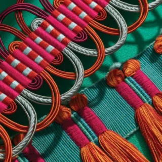 This week’s #craftfocus is passementrie. 

Passementerie is the making of elaborate trimmings such as tassels, braids, gold or silver cord, fringing or edgings for clothing or furnishings.

Skills involved in passementerie comprise dyeing, cord-spinning, weaving and tassel-making, which are coordinated to produce mainly bespoke work.

Dyeing - although usually carried out in independent dye workshops, the dyeing of silk yarn to match the furnishing fabrics on which the trimmings are to be mounted is integral to the design of the end product.

Cord-spinning - whereby component parts used in weaving and tassel-making are produced. The cord-spinner produces ropes, cords and gimps which can be immensely complex, and it is this aspect of passementerie which is most at risk, as it can only be learned by watching and following an already skilled craftsperson.

Weaving - bands, braids and fringes of a range of different formations are woven on a ‘trimmings’, ‘ribbon’ or ‘narrow’ loom. 

Tassel-making - the making of tassels and tassel tie-backs, usually using a wooden mould in the centre and covered with silk or other threads, and with gimps and bullions made by the cord-spinner, and often made to co-ordinate with the woven trimmings. The tassel-maker, like the weaver, attaches handmade ‘hangers’, ‘drops’ and ‘jasmines’.

Passementerie is classified as endangered on our crafts list. Increasingly, passementerie is manufactured in greater quantities on power machinery by large manufacturers, and in many countries. While there is still a place for handmade pieces, the market is small, with competition between companies. 

Training is often done in-house, without any system of qualification or professional recognition. Cord-spinning is considered the most at risk element and many practitioners are reaching retirement age.

Images: Elizabeth Ashdown @ashdowntextiles

#heritagecrafts #craftfocus #passementerie